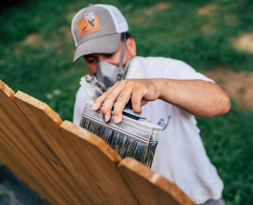 Applying Weatherproofing Paint on a Fence